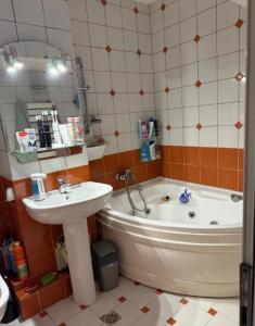 une salle de bain avec un lavabo, une baignoire et un miroir dans l'établissement New Abbey Royal Nest, à Kilcullen