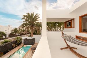 a villa with a hammock and a swimming pool at Canaryislandshost l Pausa in Costa Teguise