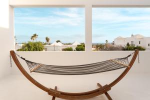 a hammock in a window with a view of the ocean at Canaryislandshost l Pausa in Costa Teguise