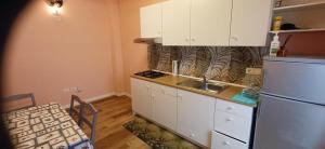 a kitchen with white cabinets and a refrigerator and a table at la primavera in Palmi