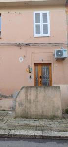 a pink building with a door and a window at la primavera in Palmi