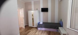 a small bedroom with a bed and a refrigerator at la primavera in Palmi