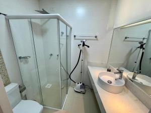 une salle de bain avec une douche en verre et un lavabo dans l'établissement Apto Frente Mar Itapema Canto da Praia, à Itapema 9 autres photos