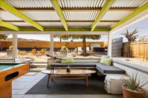 d'une terrasse avec un canapé et un billard. dans l'établissement Rancho Relaxo - hot tub, fire pit, open air bath and comfy beds, à Twentynine Palms