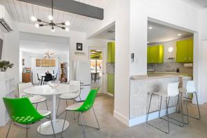 une cuisine et une salle à manger avec des chaises vertes et une table dans l'établissement Rancho Relaxo - hot tub, fire pit, open air bath and comfy beds, à Twentynine Palms