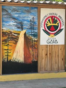 un panneau sur le côté d'un bâtiment avec une tente dans l'établissement Aldeia Gaia Nordeste, à Nísia Floresta