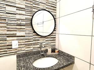 ein Badezimmer mit Waschbecken und Spiegel in der Unterkunft Casa 01 - Casa com 2 quartos, próximo a rodoviária e aeroporto in Palmas + 20 Fotos