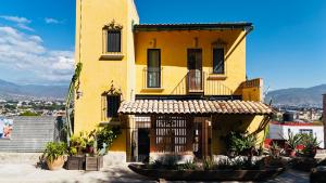 un bâtiment jaune avec des plantes devant lui dans l'établissement El Diablo y La Luna B&B by El Diablo y La Sandia, à Oaxaca
