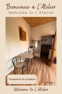 Una habitación con una mesa y sillas y una cocina. en L'atelier, en Festigny