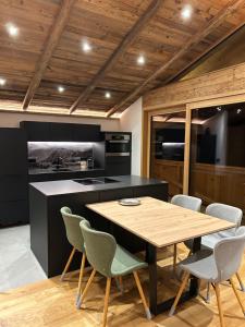 eine Küche mit einem Holztisch und Stühlen in der Unterkunft Mountainview-Lodge exklusiver Neubau mit Bergblick in Reith bei Kitzbühel