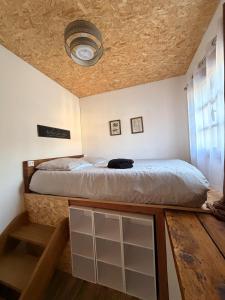 Un dormitorio con una cama y un techo. en L'atelier, en Festigny