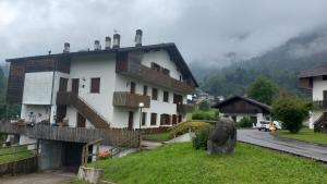- un bâtiment blanc avec un balcon dans une rue dans l'établissement Sole & Luna Dolomiti House, à Voltago