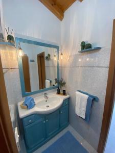 une salle de bain avec un lavabo bleu et un miroir dans l'établissement Sole & Luna Dolomiti House, à Voltago