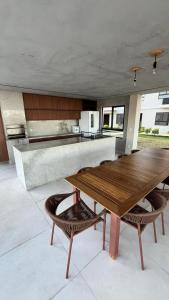 a kitchen with a wooden table and some chairs at Seu Descanso a Beira Mar in Ilhéus