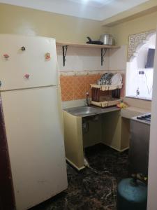 a kitchen with a white refrigerator and a sink at Dar Sofiane in Sidi Bouzid +3 photos