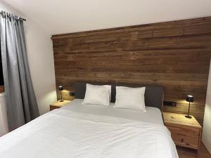ein Schlafzimmer mit einem großen Bett mit einem hölzernen Kopfteil in der Unterkunft Mountainview-Lodge exklusiver Neubau mit Bergblick in Reith bei Kitzbühel