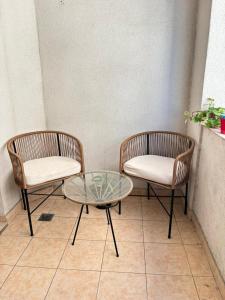 two wicker chairs and a glass table in a room at Excelente ubicación céntrica Dpto de categoría con cochera in Salta