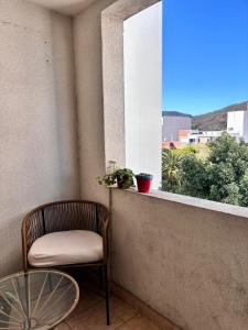 a chair and a table on a balcony with a window at Excelente ubicación céntrica Dpto de categoría con cochera in Salta