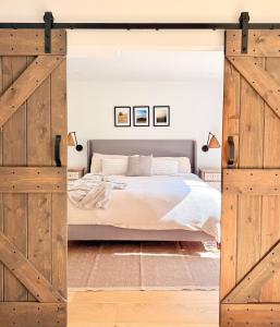 une chambre avec un grand lit avec des portes en bois dans l'établissement Sage Sanctuary - Private Oasis Getaway, à Ojai 27 autres photos