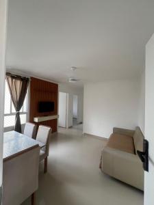 un soggiorno con un divano e un tavolo di Ape 2 quartos a Guarujá