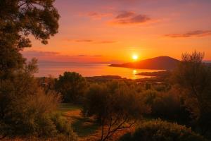 einen Sonnenuntergang über dem Wasser mit einem Berg in der Unterkunft Azulik Corsica in Corbara + 6 Fotos