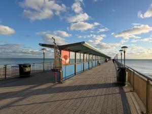 a boardwalk on the beach with a building on it at Seabreeze Suits Boscombe in Bournemouth