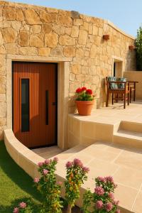 a wooden front door of a stone building with flowers at Azulik Corsica in Corbara +2 photos