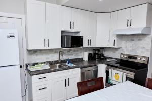 a kitchen with white cabinets and a sink at Anukc in Prince George