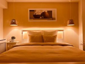 ein Schlafzimmer mit einem Bett, über dem zwei Lampen hängen in der Unterkunft Otopeni Airport Apartment - King Bed - Free Shuttle Included Near Therme in Otopeni + 12 Fotos