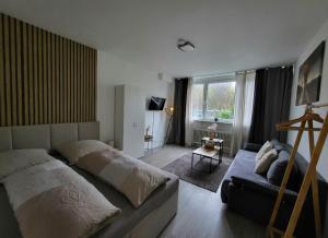 ein Schlafzimmer mit einem großen Bett und einer Couch in der Unterkunft Stilvolle Wohnung in Wuppertal inkl. Kaffee & Tee in Wuppertal