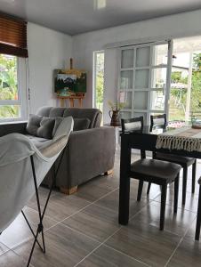 salon z kanapą i stołem w obiekcie Encantador refugio con piscina a 20 minutos de Villeta w mieście Guadual