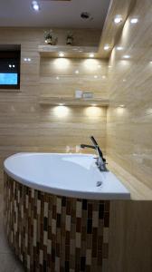 La salle de bains est pourvue d'une baignoire et d'un lavabo. dans l'établissement Domki nad jeziorem Ostoja Głuszyńska, à Potołówek