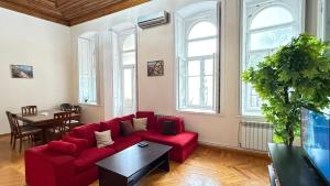 a living room with a red couch and a table at Old city apart in Baku