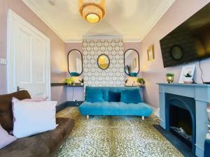 ein Wohnzimmer mit einer blauen Couch und einem Kamin in der Unterkunft Bournemouth Beach Boutique with Hot Tub in Bournemouth + 37 Fotos