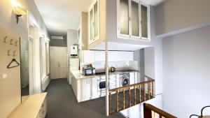 a small kitchen with white cabinets and a microwave at Old city apart in Baku