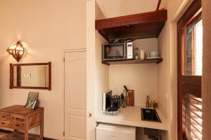 a kitchen with a microwave on a wall at Goood Resort in Kralendijk