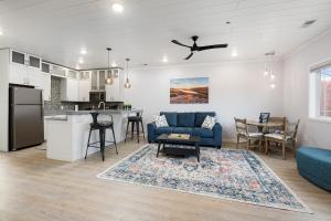 a living room with a blue couch and a kitchen at Slabtown Penthouse - Modern Condo - Private Rooftop Deck 