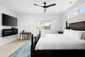 a bedroom with a bed and a flat screen tv at Slabtown Penthouse - Modern Condo - Private Rooftop Deck 