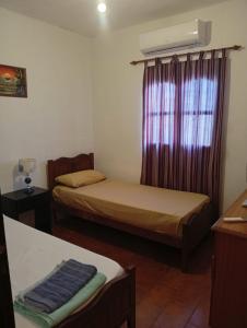 ein kleines Zimmer mit zwei Betten und einem Fenster in der Unterkunft Alojamiento Valle del Sol in San Fernando del Valle de Catamarca