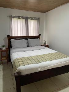 a large bed in a bedroom with a window at Alojamiento con lago privado en Bajos del Toro in Toro Amarillo