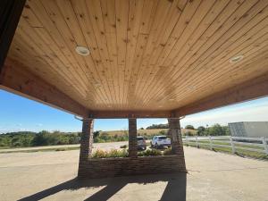 um pavilhão com telhado de madeira e estacionamento para carros em Covered Bridge Inn em Winterset
