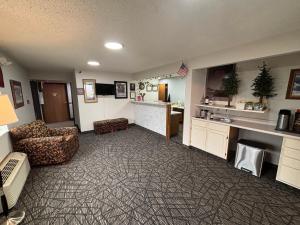 un soggiorno con divano e sedie e una cucina di Covered Bridge Inn a Winterset