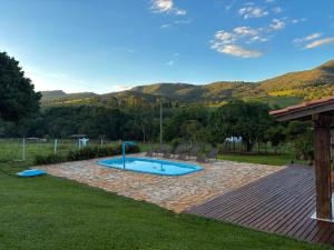 - une piscine dans une cour avec des montagnes en arrière-plan dans l'établissement Pousada Império de Minas, à Capitólio