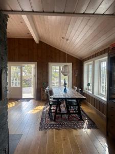 Rustik hytte i Gausta, ski in, ski out, 10 beds في Gaustablikk: غرفة طعام مع طاولة وكراسي خشبية