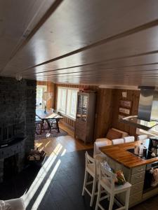 Rustik hytte i Gausta, ski in, ski out, 10 beds في Gaustablikk: مطبخ وغرفة معيشة مع طاولة وكراسي