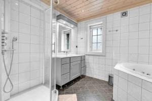 Rustik hytte i Gausta, ski in, ski out, 10 beds في Gaustablikk: حمام مع دش ومغسلة وحوض استحمام +104 صور