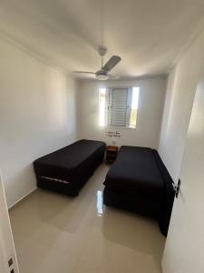 una camera da letto con due letti e un ventilatore a soffitto di Ape 2 quartos a Guarujá