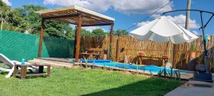 einen Pool mit Pavillon und Sonnenschirm in der Unterkunft Quincho Gala in El Cadillal