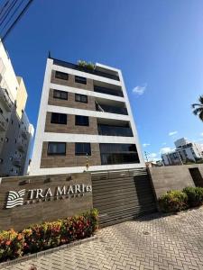 ein hohes Gebäude mit einem Schild davor in der Unterkunft a melhor custo beneficio de INTERMARES - Tra Mari in Cabedelo