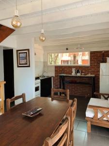 a kitchen and dining room with a wooden table and chairs at Nuevos Aires in Mar de las Pampas +16 photos